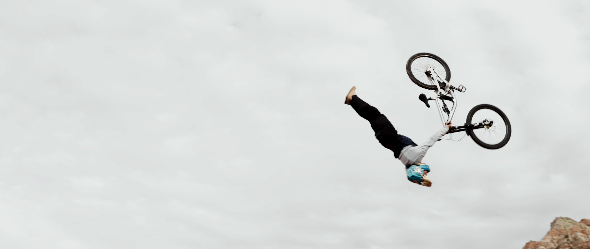 Person performing a bike trick against a cloudy sky