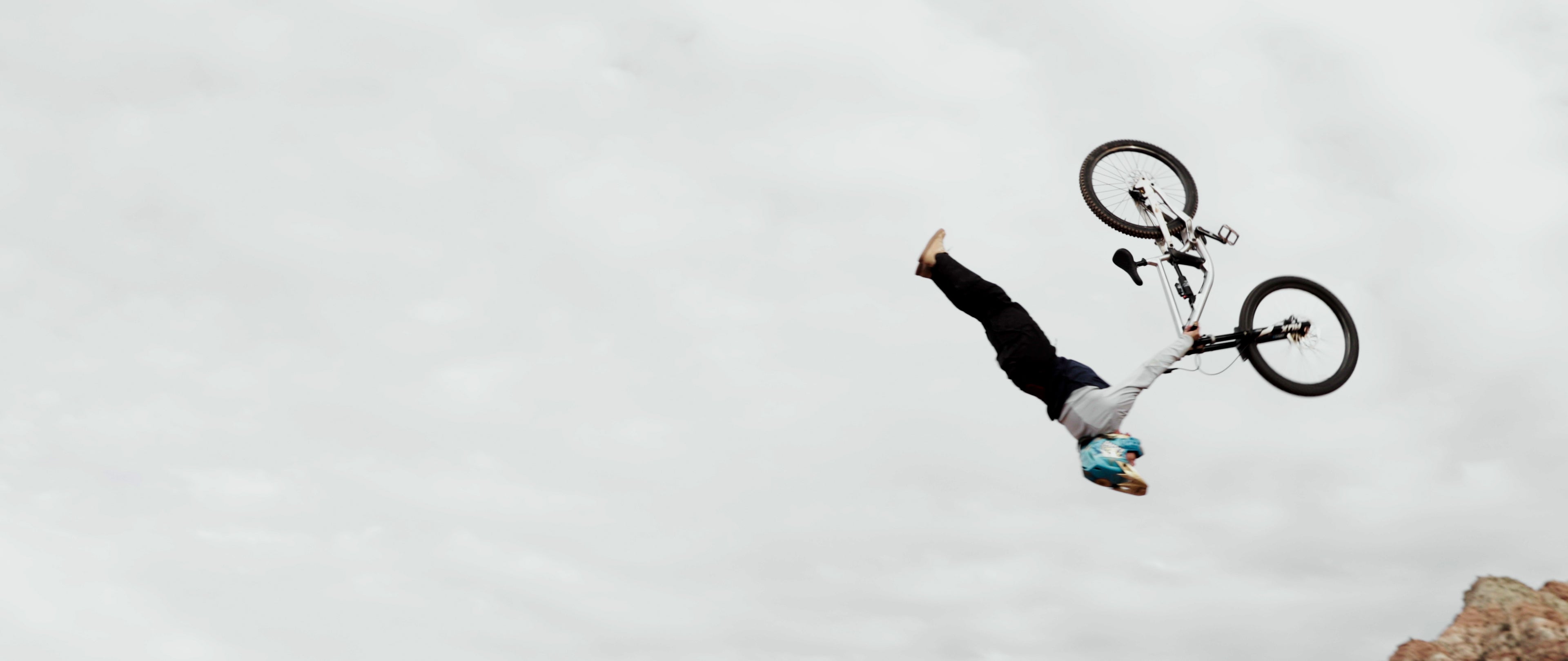 Person performing a bike trick against a cloudy sky