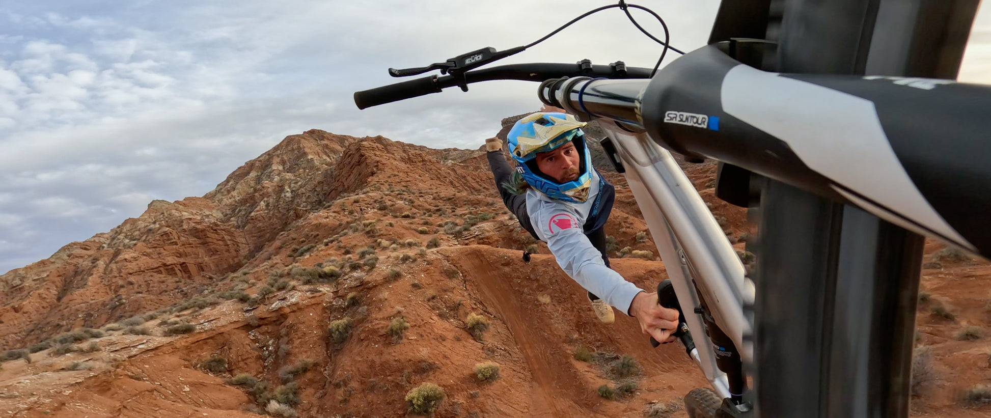 Person on a mountain bike in a desert landscape with rocky hills.