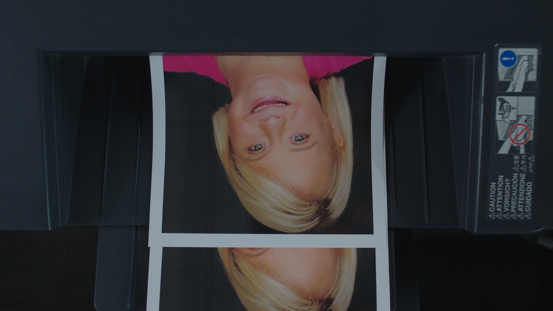 Close-up of a printed photo with a person's face, coming out of a printer.