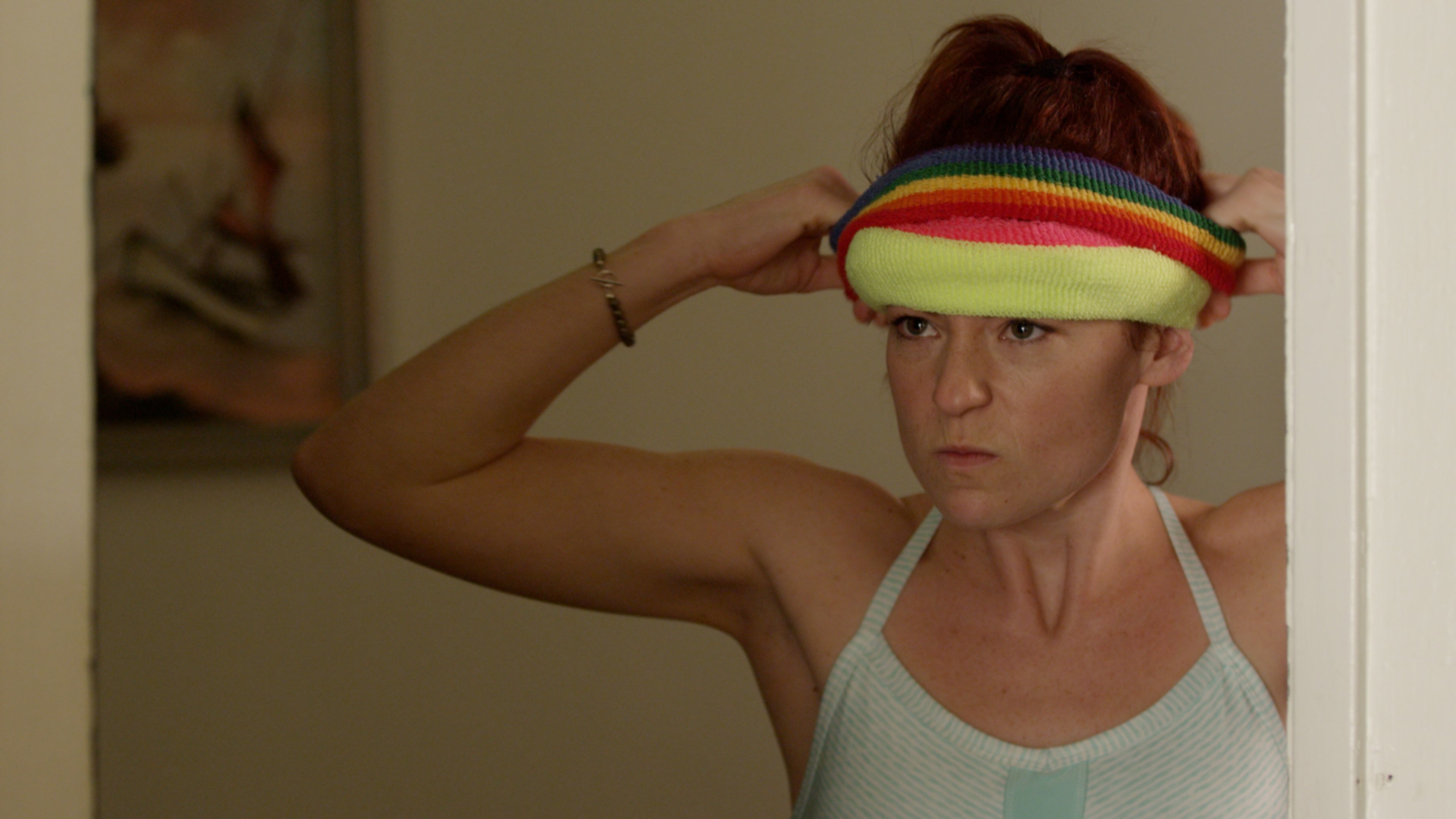 Person wearing a colorful headband with a neutral background