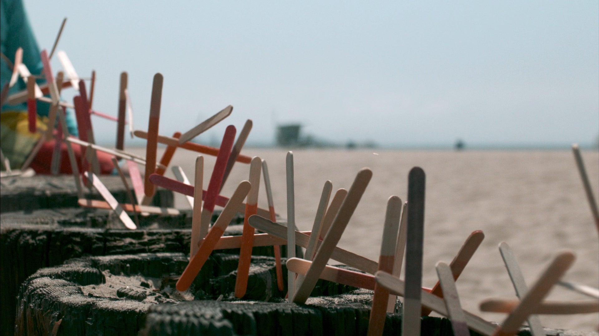Colorful clothespins on a line with a blurred beach background
