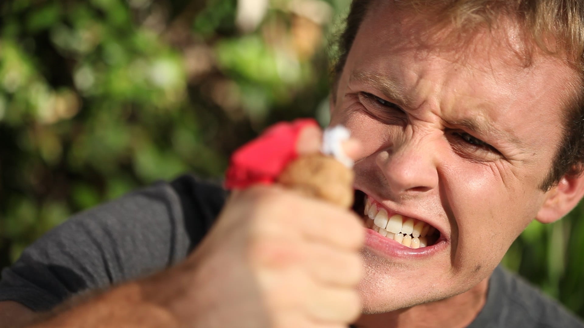 A person cracking a nut with his finger. 
