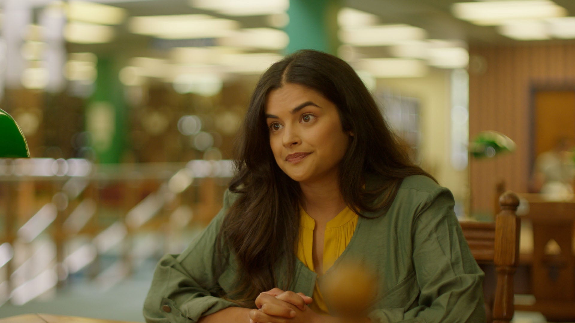 Woman sitting in a casual setting with a blurred background